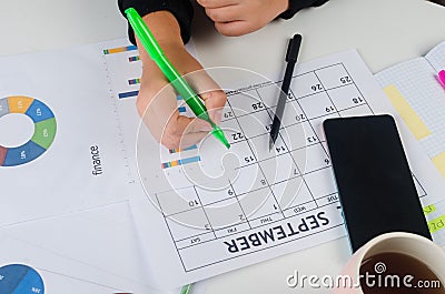 Girl Hands With Mobile Phone With Calendar Writing And List Of Work In Diary On Desk Stock Photo