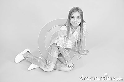 Girl happy face sit on floor attentive looking at camera turquoise background. Kid girl with long hair relaxing. Just Stock Photo