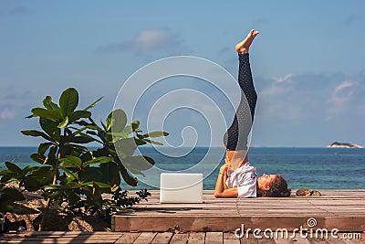 Girl has a yoga practice on the wooden floor with laptop Stock Photo