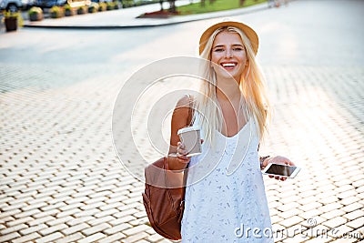 Girl in hat holding take away coffee cup and smartphone Stock Photo