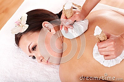 Girl having Thai herb compress massage. Stock Photo