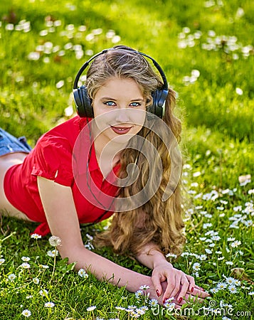 Girl in headphones catch rhythm music on green grass Stock Photo