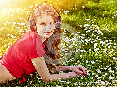 Girl in headphones catch rhythm music on green grass Stock Photo