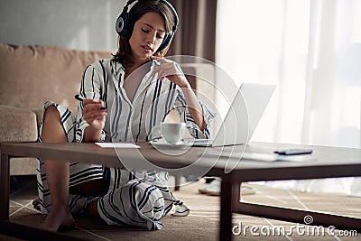 Girl with headphones using laptop in her home Stock Photo