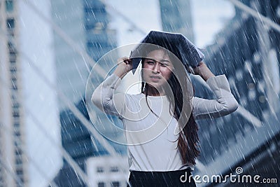 Girl in the heavy rain storm cover head with newspaper for economic obstacle Stock Photo