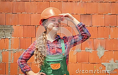 girl in helmet is construction worker. foreman teen child. kid work in the helmet. little girl in a helmet. girl making Stock Photo