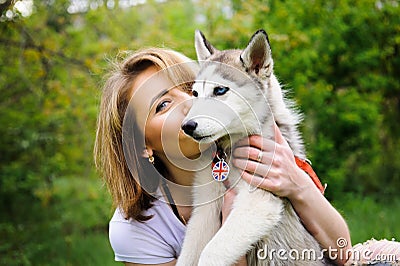 A girl and her dog husky walking in a park Stock Photo