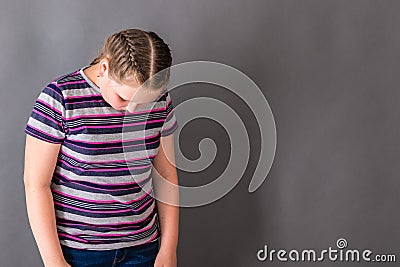 A girl with her head lowered, ashamed of her bad school success Stock Photo