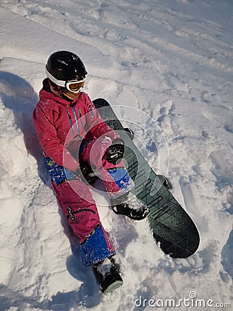 A girl with her snowboard and her first practice for snowboarding at Niseko illage, Sapporo , Japan Editorial Stock Photo