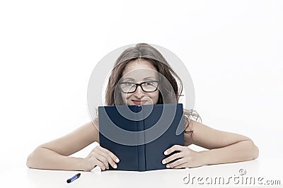 Girl hiding behind book looking at camera. flirt and desire. girl read book in glasses. Introverted or extrovert girl Stock Photo