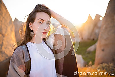 girl hiker in poncho on top of mountain at sunset Stock Photo