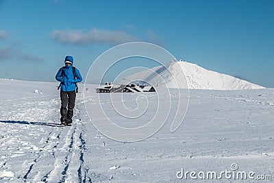 Girl hiking in Krkonose on sunny winter day with Snezka and Lucni bouda in background, Krkonose mountains, Czech republic Editorial Stock Photo