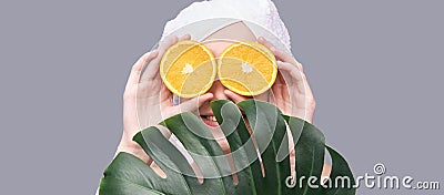 Girl hold orange slice. Citrus fruit hidding face Stock Photo