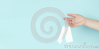 Girl holding badge with price tag on blue background. Copy space Stock Photo