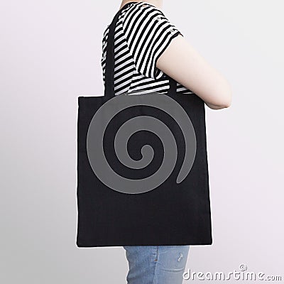 Girl is holding black cotton eco tote bag, design mockup. Stock Photo