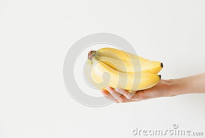 The girl is holding a bunch of bananas in her hand. Daylight, space for your text. Stock Photo