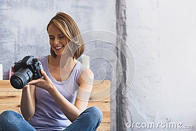 Girl holding camera and smiling Stock Photo