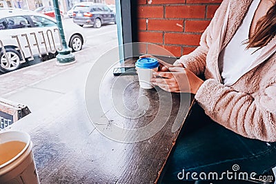 A girl holding a cup of coffee with a blue lid Stock Photo