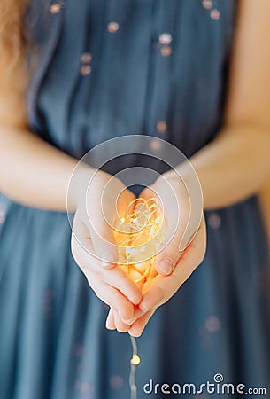 girl holding decorative garland palms warm light Stock Photo