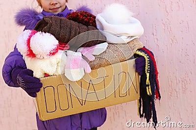 Girl holding donation box with winter clothes Stock Photo