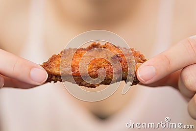 A girl holding and eatting fried chicken Stock Photo