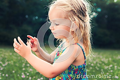 Girl holding grasshopper, curiosity and education concept Stock Photo