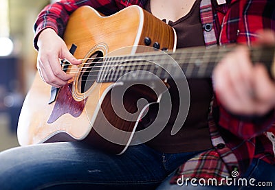 Girl holding guitar. Focus on strings of guitar Stock Photo