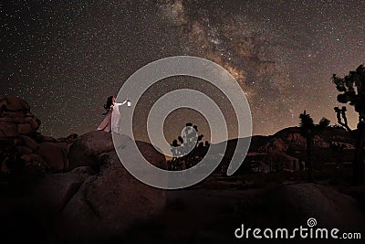 Girl Holding Lantern in the Desert Under the Milky Way Stock Photo