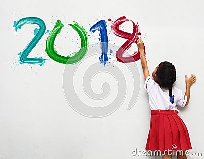 Girl holding a paint brush painting happy new year 2018 Stock Photo