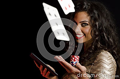 Girl holding poker chips and tablet, black background Stock Photo