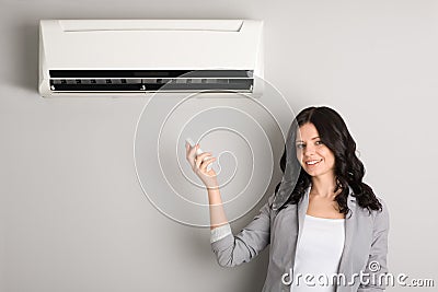 Girl holding a remote control air conditioner Stock Photo