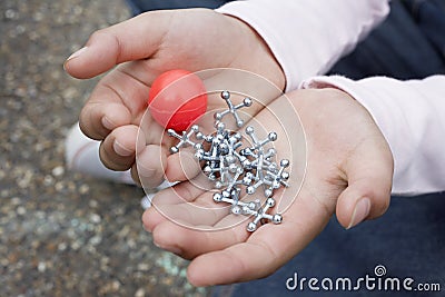 Girl Holding Rubber Ball And Jacks Stock Photo