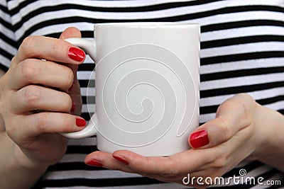 Girl is holding white cup in hands. Stock Photo