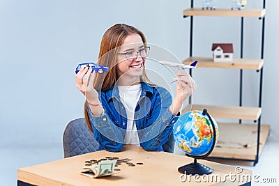 Girl holds airplane and car models in hands and choosing best transportation for trip.Travel around the world for your Stock Photo