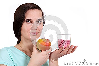 The girl holds apple and vitamins in hand Stock Photo