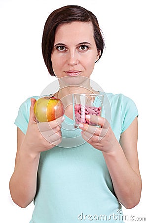 The girl holds apple and vitamins in hand Stock Photo