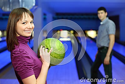 Girl holds ball for bowling and man look at it Stock Photo