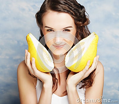 Girl holds in really big citrus fruit - pamelo Stock Photo