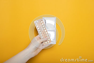 The girl holds contraceptive pills and condoms in her hands Stock Photo