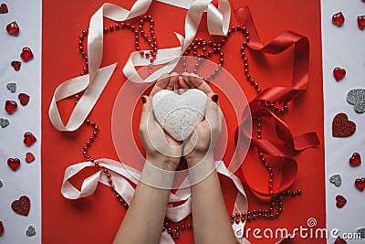 The girl holds the heart in her hands on a festive background. Stock Photo