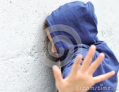 Girl trying to protect herself from the attacker with her hand Stock Photo