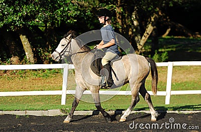 Girl in horse riding lesson Stock Photo