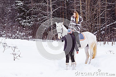 Girl, horse trainer and white horse in a winter Stock Photo