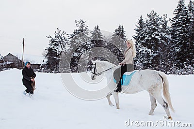 Girl, horse trainer and white horse on a winter Stock Photo