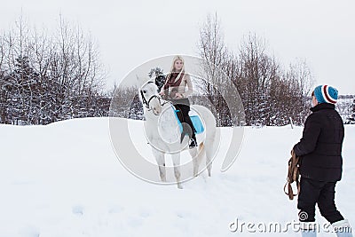 Girl, horse trainer and white horse on a winter Stock Photo