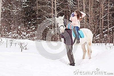 Girl, horse trainer and white horse in a winter Stock Photo