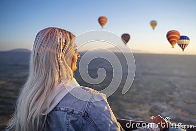 Girl in a hot air balloon watching the sunrise, hot air balloons during sunrise Stock Photo