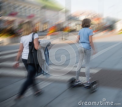 Girl on the hoverboard on the street of the city in motion blur Editorial Stock Photo