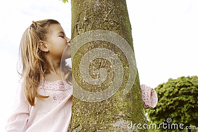 Girl hugging tree in park. Stock Photo