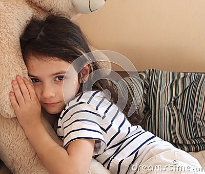 a girl hugs her favorite bear toy,a happy baby,a stuffed toy Stock Photo